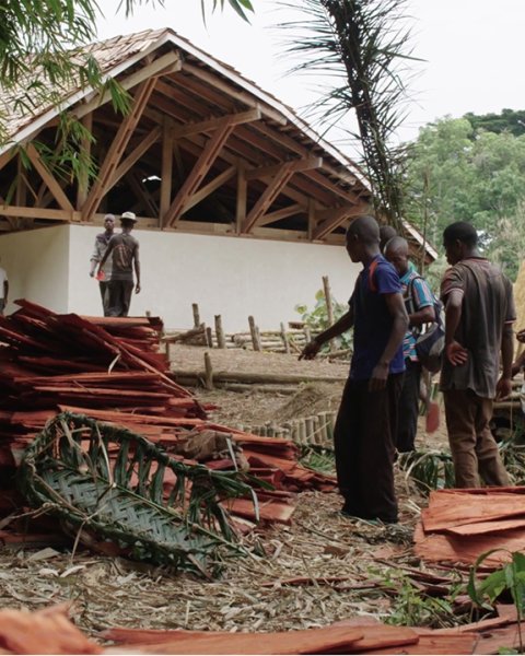 Photo of the Ilima Primary School, carpenters working on the shingles