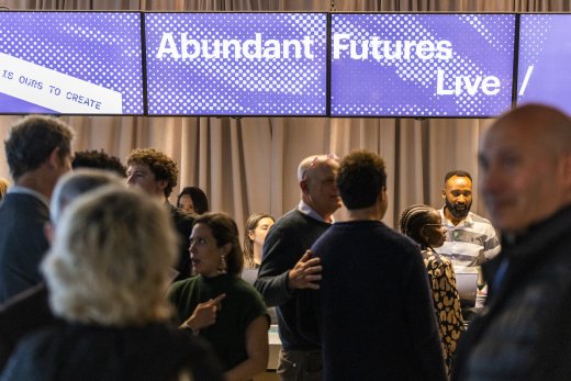 Guests at Abundant Futures / Live 2025 in front of screens with event branding.