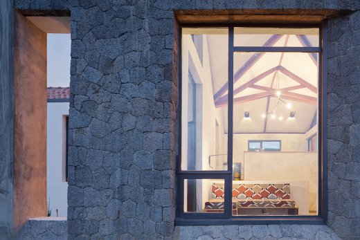 Photo of Butaro Doctors' Housing, Photo by Iwan Baan, Nightime View of Window Frame and View into Living Room