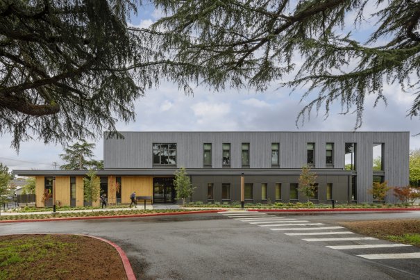 The Washington State School for the Blind’s Life Skills Training Center, viewed from the outside across the street. The exterior materials balance residential character with durability and sustainability, and the scaling and stepping of building volumes creates opportunities for passive window shading and covered outdoor porches, contributing to a welcoming presence from the street.
